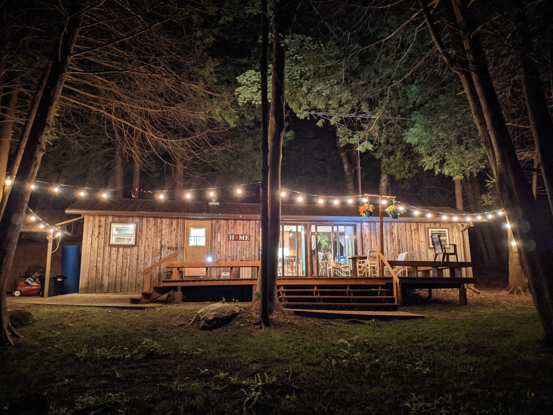 Cedar Park cabin at night with café lights